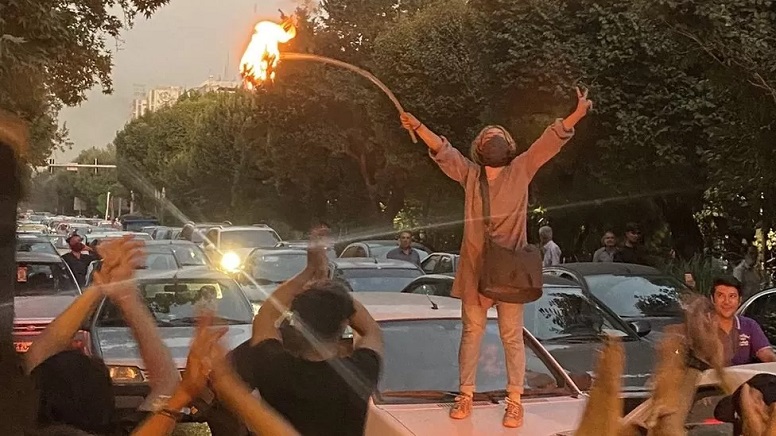 A woman set fire to her headscarf during a protest in Tehran on Monday A woman set fire to her headscarf during a protest in Tehran on Monday